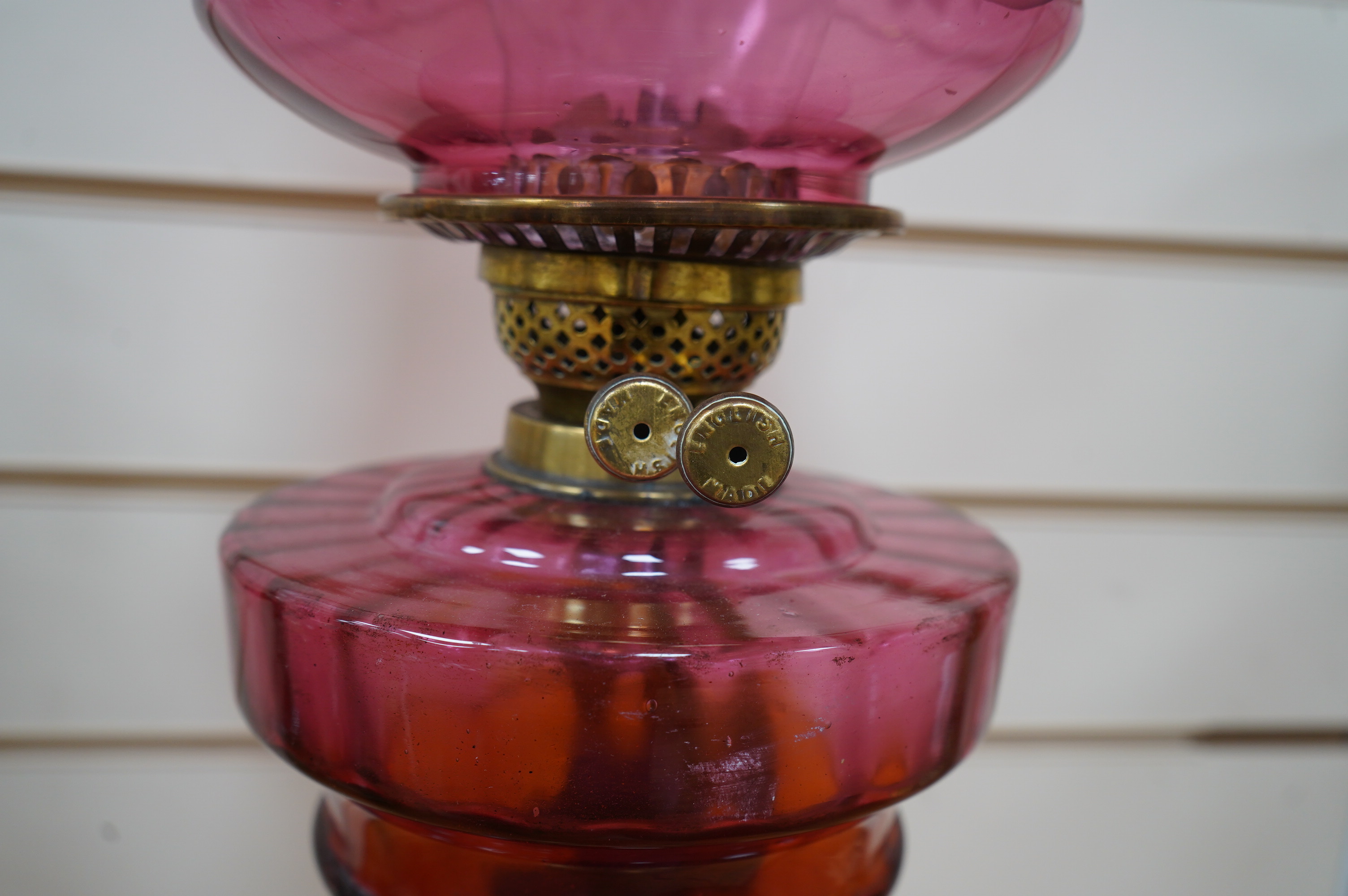 A Victorian oil lamp on brass base with cranberry font, acid etched cranberry shade chimney, overall 62cm high. Condition - good